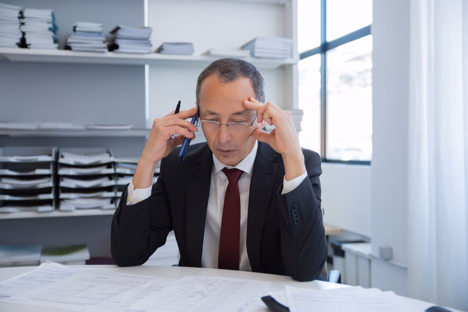 Angespannter Unternehmer mittleren Alters bei einem Telefonat